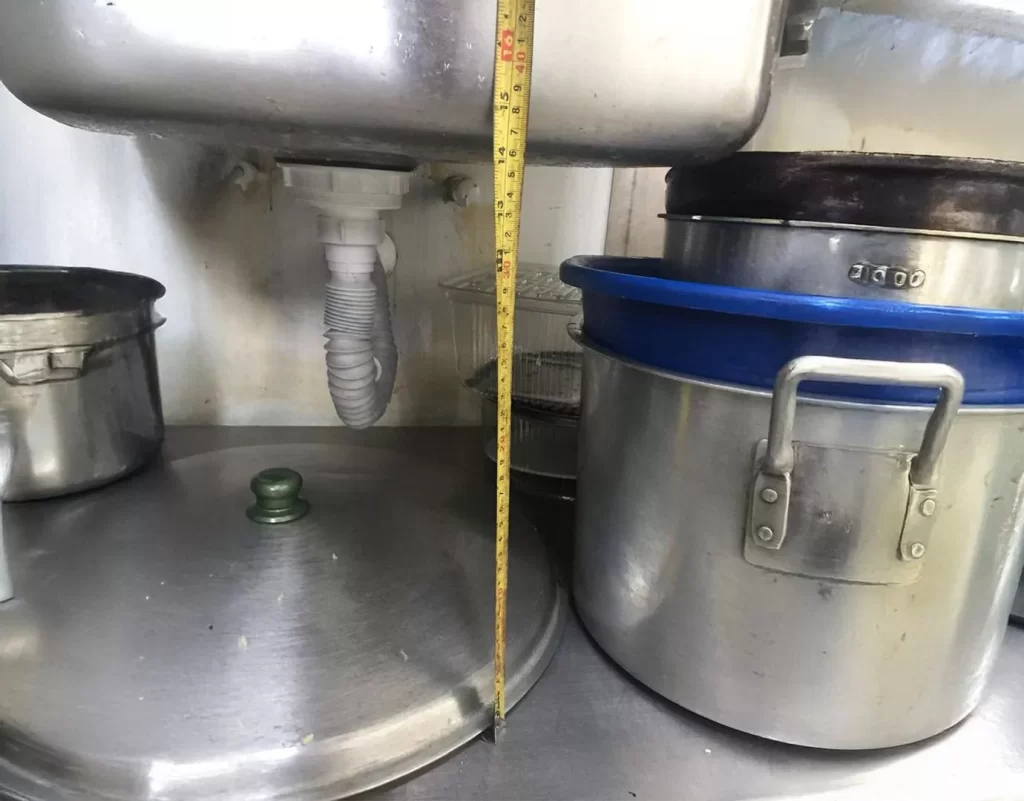 Medición de la altura desde la base de una tarja industrial como parte del diseño de sistemas de filtración y trampas de grasa.